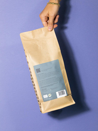 Rückansicht einer 1kg Packung Clean Coffee Bio Kaffee in einer Hand