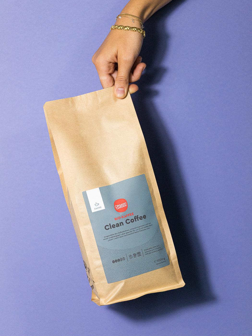 Frontansicht einer 1kg Packung Clean Coffee Bio Kaffee in einer Hand