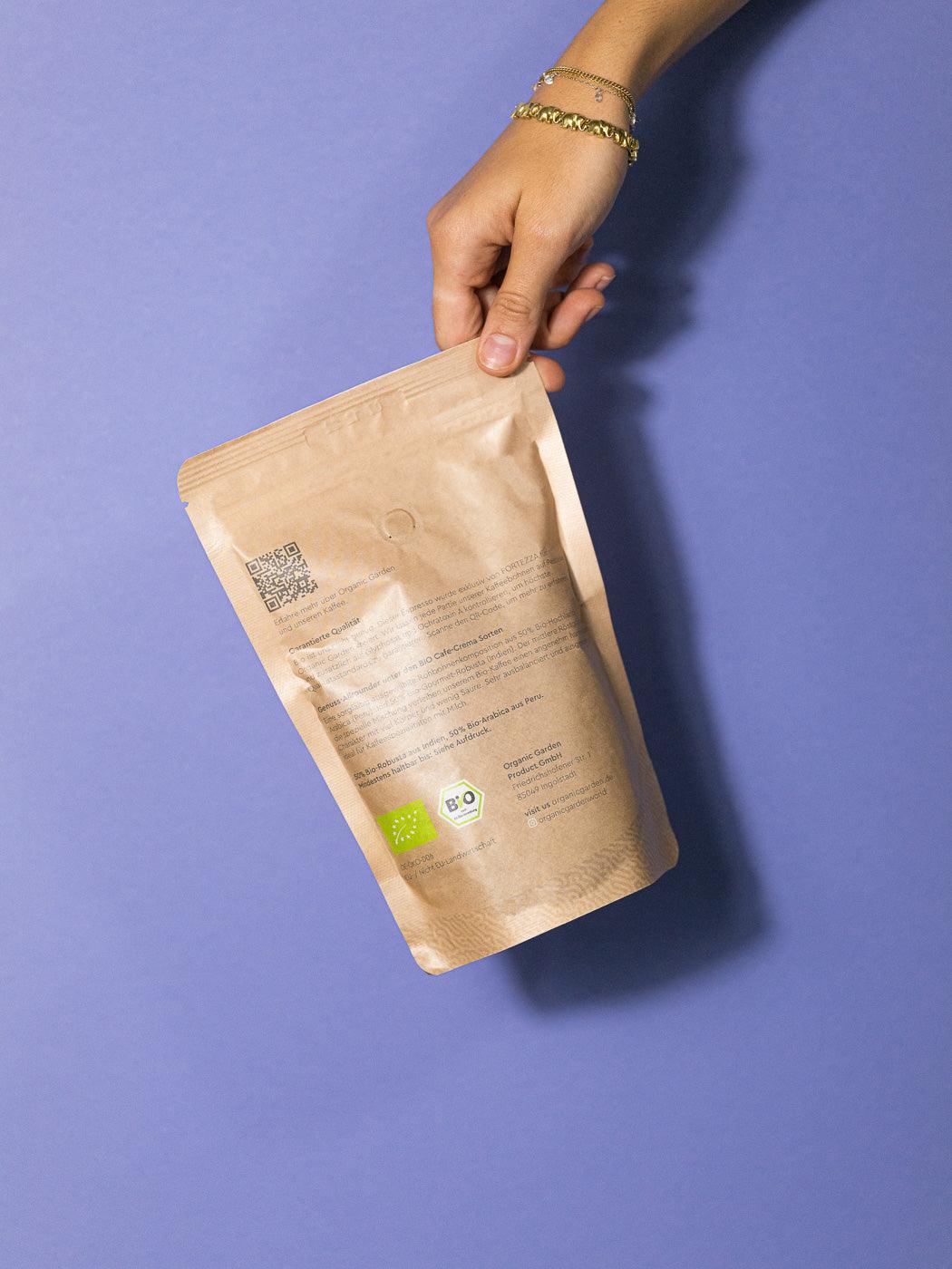 Rückansicht einer 250g Packung Clean Coffee Bio Kaffee in einer Hand