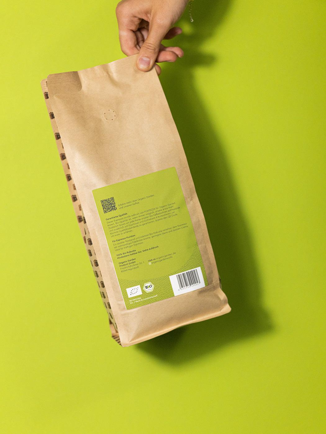 Frontansicht einer 1kg Packung Clean Coffee Bio Espresso in einer Hand