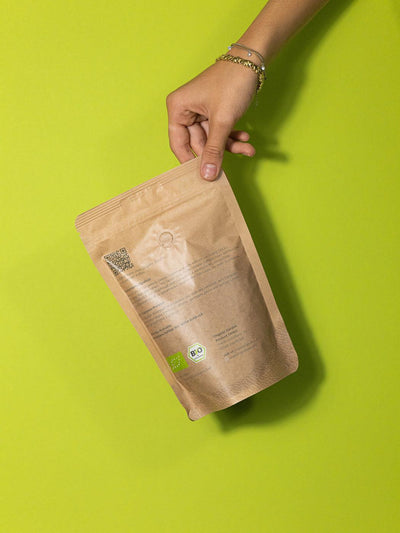 Rückansicht einer 250g Packung Clean Coffee Bio Espresso in einer Hand